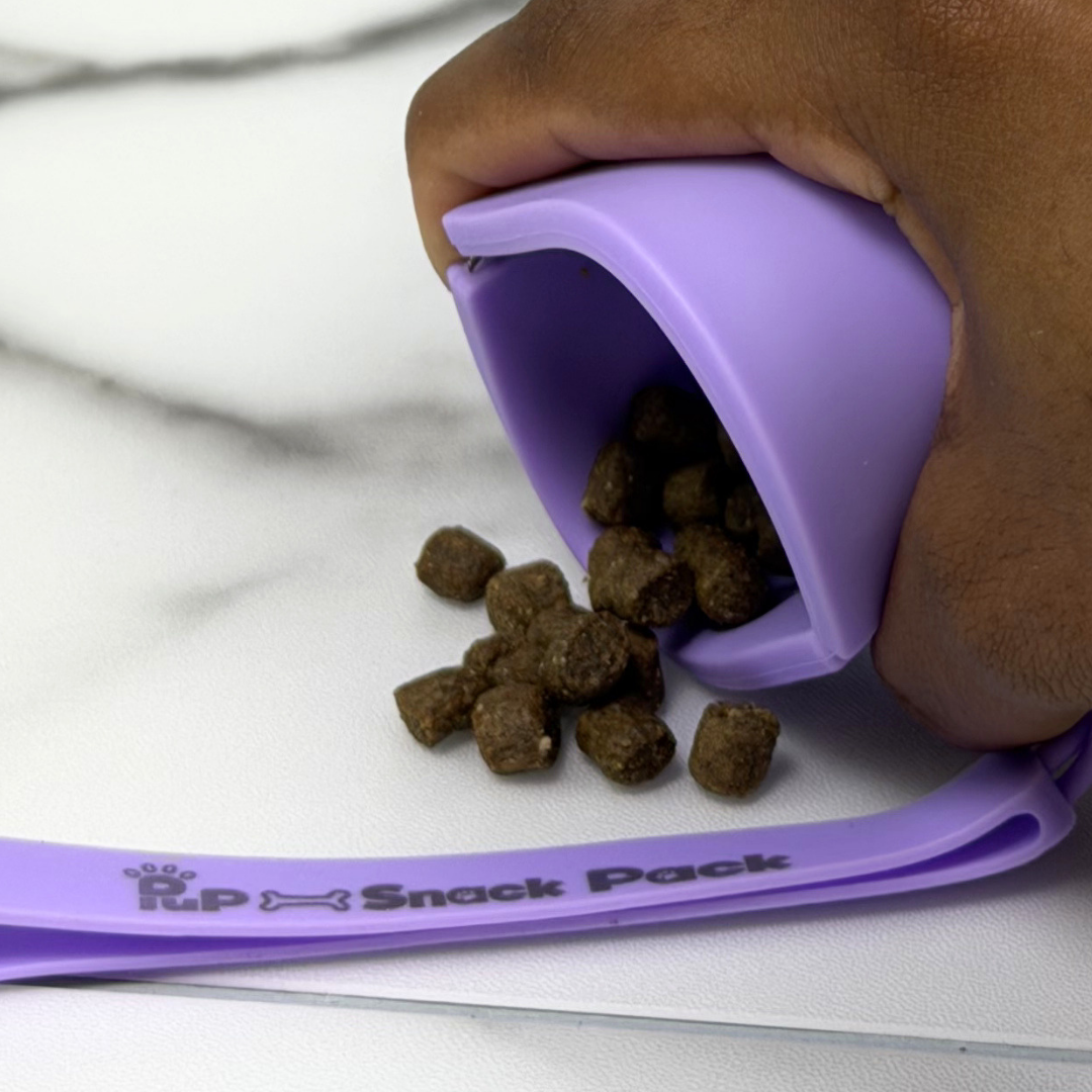 Purple pet snack pack with pet food being poured out onto a white surface