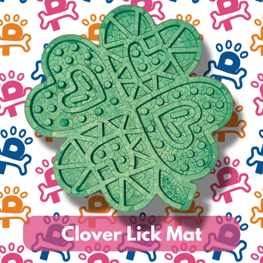 A green Clover Lick Mat designed for dogs to lick treats off, displayed on a background with colorful paw prints.