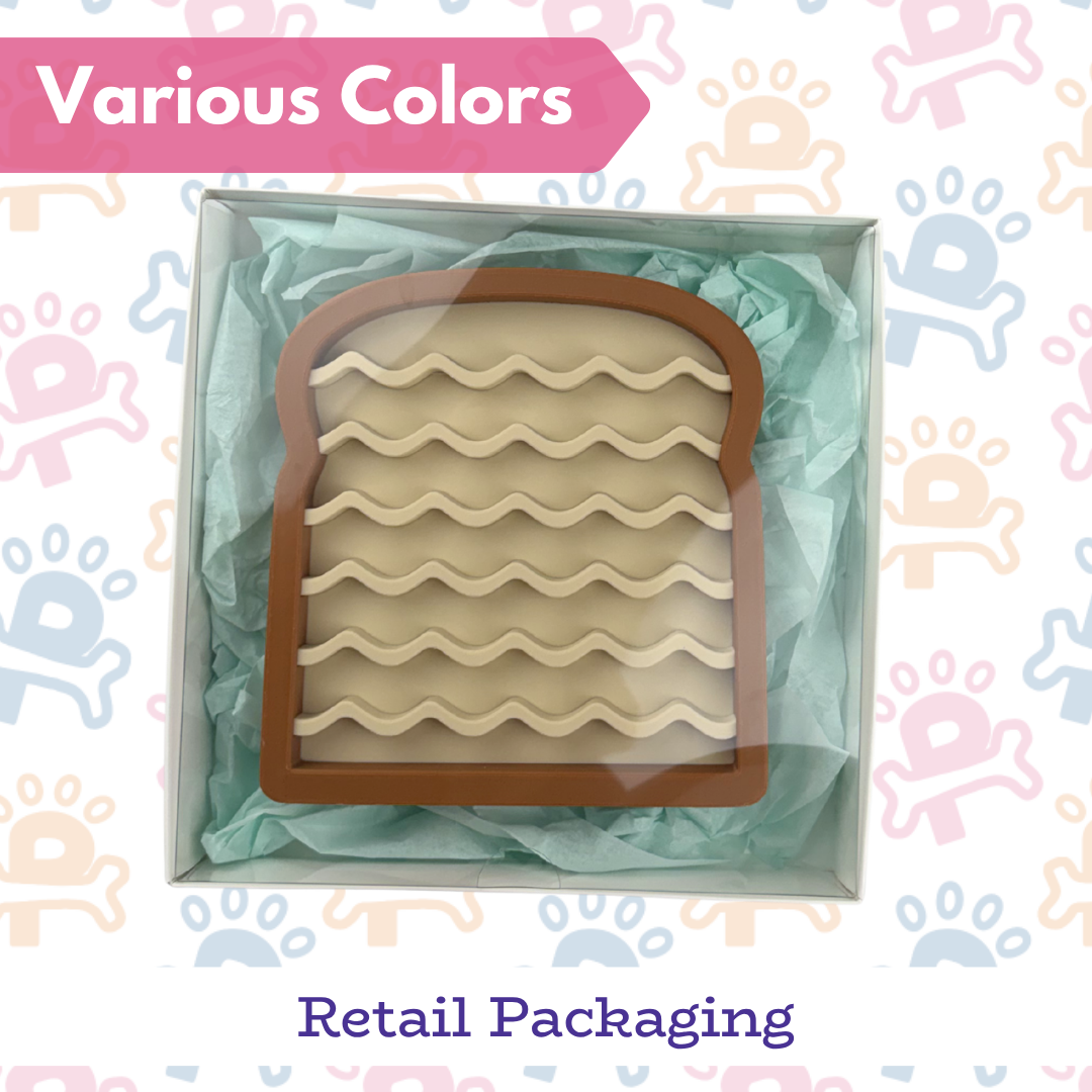 Cookie cutter shaped like a piece of toast with wavy bread pattern, in retail packaging.