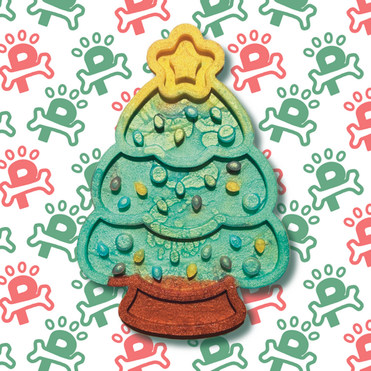 An silicone lick mat shaped like a Christmas tree, featuring textured grooves and patterns designed to hold spreads like peanut butter or yogurt for dogs to enjoy