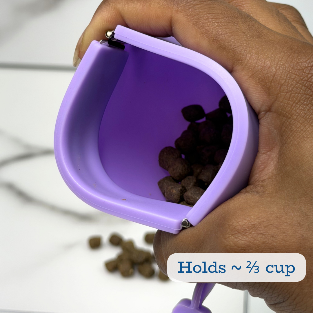 Purple pet treat container held by a hand with treats inside, on a white background.